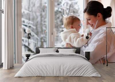 Mother and baby in the arms of a stethoscope in the winter Wall mural