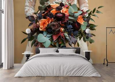 Wedding bouquet of orange, dark maroon roses and eucalyptus with teal velvet ribbons held by a bride in a wedding dress Wall mural