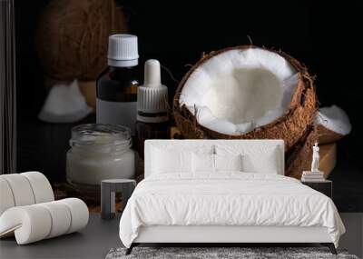 still life, coconut and oil bottles on a wooden board on a black background Wall mural