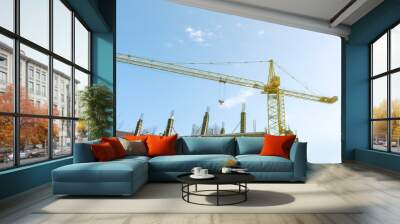 Tower crane on the blue sky background. Building construction work concept, investments in the development construction buildings and structures industry. Wall mural