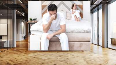 Frustrated and depressed man sitting on the edge of the bed after conflict with his wife because of his erectile dysfunction problem Wall mural