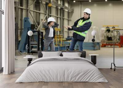 Portrait of a female factory manager in a white hard hat and business suit and factory engineer controlling the work process in the helicopter manufacturer. Factory manager shouts at factory engineer. Wall mural