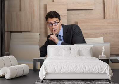 Young cunning employee in black suit working in the office and stealing information from laptop of his colleague Wall mural