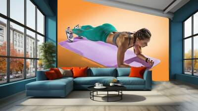 Sport. Muscular woman on a plank position use fitness gum. Muscular and strong girl exercising. Fitness exercising with expander.	 Wall mural