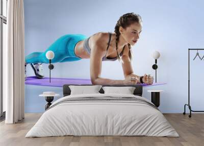 Sport. Young athletic woman doing plank. Muscular and strong girl exercising. Crossfit and fitness exercising. Wall mural