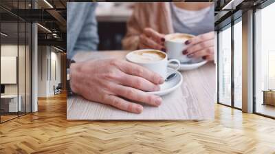 Hands on the table holding cups of coffee Wall mural