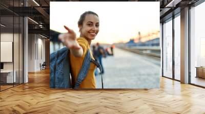 portrait of a young woman traveler with small backpack on the railway stantion Wall mural