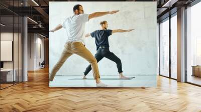 two young sporty men practicing yoga in gym.  Wall mural