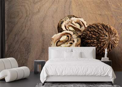 Black walnuts on wooden background. Wall mural