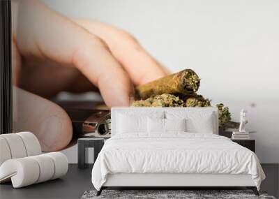 Hands on white background holding a cannabis joint and marijuana. Smoking marijuana addiction. Wall mural