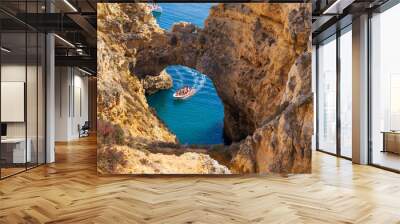 Tourists on motor boat at the cathedral arch at Ponta da Piedade, Algarve coast, Lagos, Portugal. Wall mural