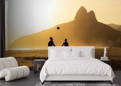 Two Brothers Mountain behind 2 friends playing soccer at Ipanema Beach, Rio de Janeiro. Sunset at summer Wall mural