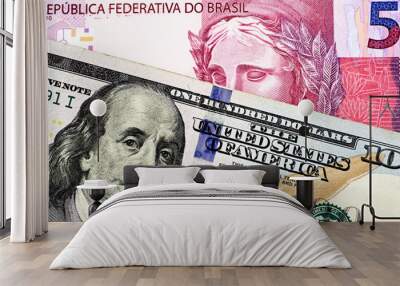 A macro image of a pink five Brazilian reais bank note with a close up image of a blue, one hundred American dollar bill close up Wall mural