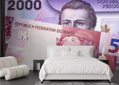 A purple two thousand Chilean peso bill with a pink Brazilian five reais note close up Wall mural