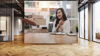 happy young asian woman customer smiling receive parcel post box from home delivery service man in blue uniform at home, express home delivery service, transport logistics and online shopping concept Wall mural