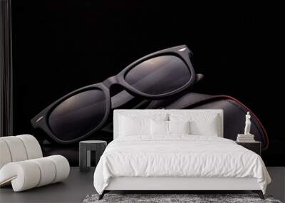 Black sunglasses with case on black background. Wall mural