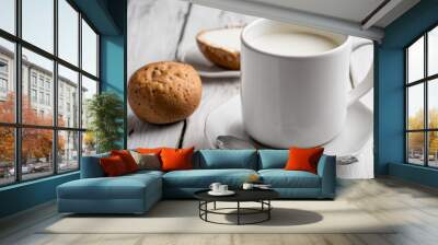 A white cup of milk and a cookie on a table Wall mural