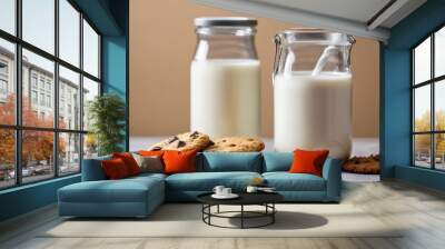 Two jars of milk and two cookies on a table Wall mural