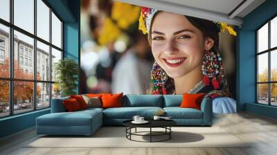 A beautiful Albanian woman. Albania. A beautiful Albanian woman. A smiling young woman in traditional attire adorned with colorful jewelry and a floral headdress stands against a vibrant backgr. #wotw Wall mural