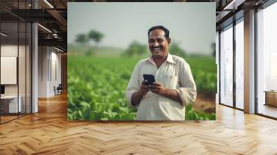 An indian farmer using his smart phone in the fields remotely Wall mural