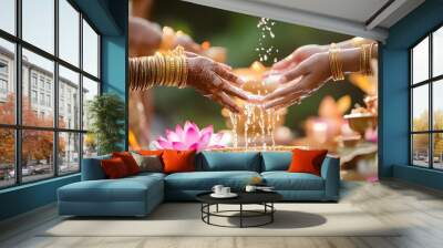 Wedding scene, A close-up of elegantly adorned hands pouring water over a decorative bowl surrounded by flowers in a serene, festive setting celebrating tradition  Wall mural