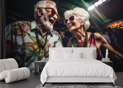 Older senior couple having a great time laughing and dancing wearing bold colorful outfits Wall mural