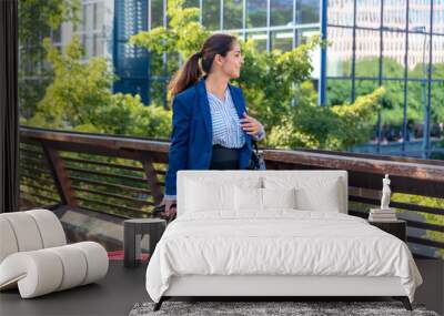 Caucasian mid adult businesswoman with suitcase in the city Wall mural