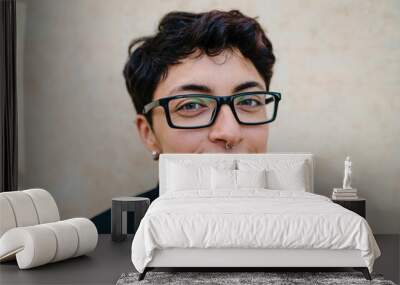 Close up view of a young transgender man looking at camera and smiling. Wall mural