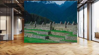 Photo of stone wall with mountains in the background. Wall mural