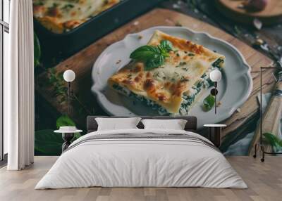 A delectable slice of spinach and ricotta lasagna topped with melted cheese and fresh basil sits gracefully on an ornate white plate. Wall mural