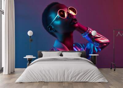 A person in glamorous, reflective clothing and vibrant pink round sunglasses poses confidently against a neon blue and pink backdrop. Wall mural