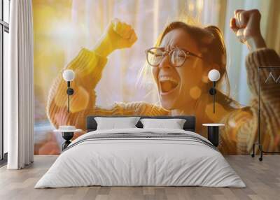 A person joyously celebrating indoors with fists in the air, immersed in the bright, morning sunlight. Wall mural