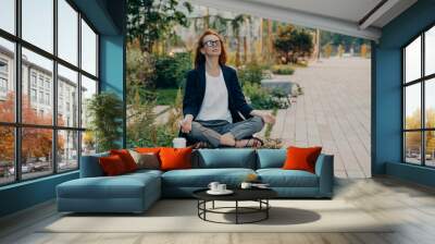 Calm business woman meditating in lotus outdoors, peaceful female freelance employee practicing yoga Wall mural