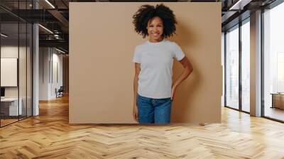 Cheerful african female in white tshirt and jeans expressing positive emotions, posing in studio Wall mural