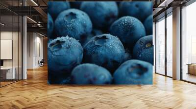 Close-up of luscious blueberries covered in tiny dewdrops, highlighting their freshness and vibrant deep blue hue. Wall mural