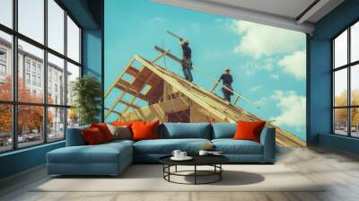 Construction workers balance on a roof frame under a bright blue sky, diligently building a new structure. Wall mural