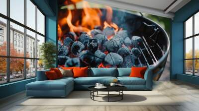 Fiery barbecue coals glow intensely within a grill, flames dancing as they prepare to cook a forthcoming meal in an outdoor setting. Wall mural