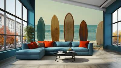 Five surfboards are lined up in the sand, patiently waiting by the shore for the next surfing adventure under a serene sky. Wall mural