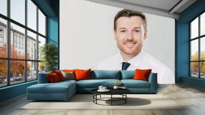 Headshot of attractive unshaven young male with cheerful expression, looks confidently at camera, being pleased to meet with colleagues, dressed in formal clothes, isolated over white background Wall mural