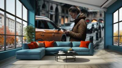 Woman in a brown coat focuses on her phone amidst a lively street scene, surrounded by architecture and passing cars. Wall mural