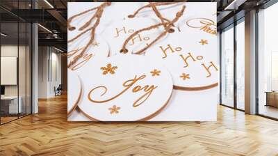 A vertical shot of Christmas tree wooden decorations with writings: Merry Christmas, Joy, Ho Ho Ho Wall mural