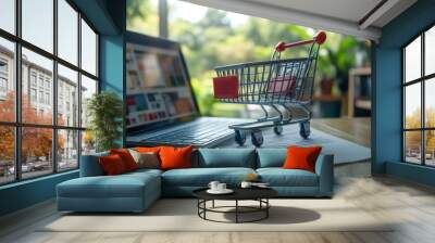 Mini shopping cart on a laptop desk, representing online retail and e-commerce in a bright modern office environment. Technology and digital commerce in business settings. Wall mural