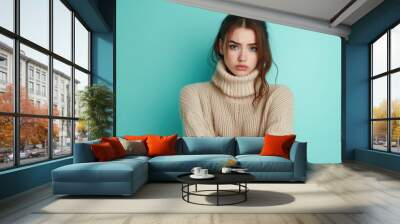 Offended Woman in Knitted Sweater. Young Caucasian Girl with Crossed Arms on Pastel Blue Studio Portrait Wall mural