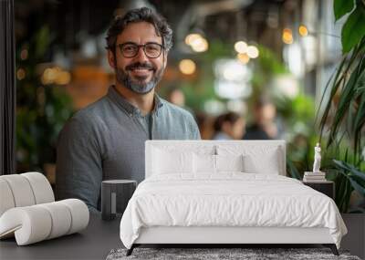 Smiling man in a modern office with greenery and soft lighting Wall mural