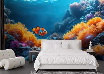 Underwater seascape featuring a vibrant orange anemonefish swimming through colorful coral reefs, deep blue ocean background highlighting marine life and natural beauty. Wall mural