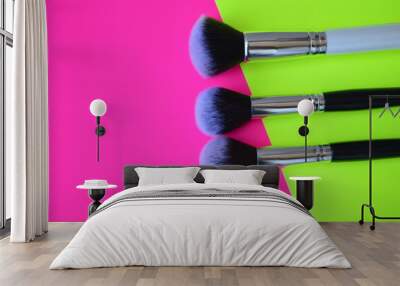 Professional cosmetic makeup brushes of different sizes on a pink and green background for applying powder, shadows and blush and other cosmetic products Wall mural