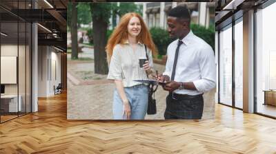 Black african american man on the street making a survey to red haired woman Wall mural