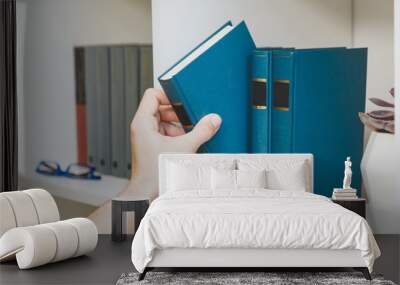 Hand taking book from the shelf Wall mural