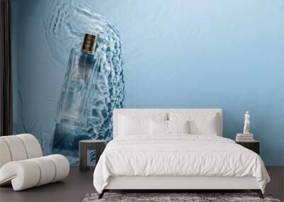 perfume bottle on blue water wavy background. fresh sea fragrance concept. women's and men's essence Wall mural