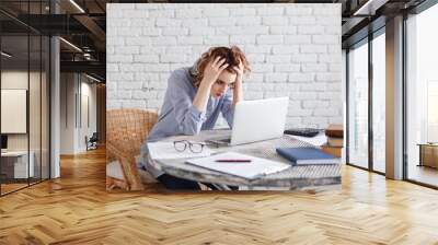 Portrait of tired young business woman with laptop computer Wall mural